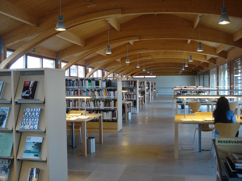 Biblioteca donde se ven mesas y estanterías con libros